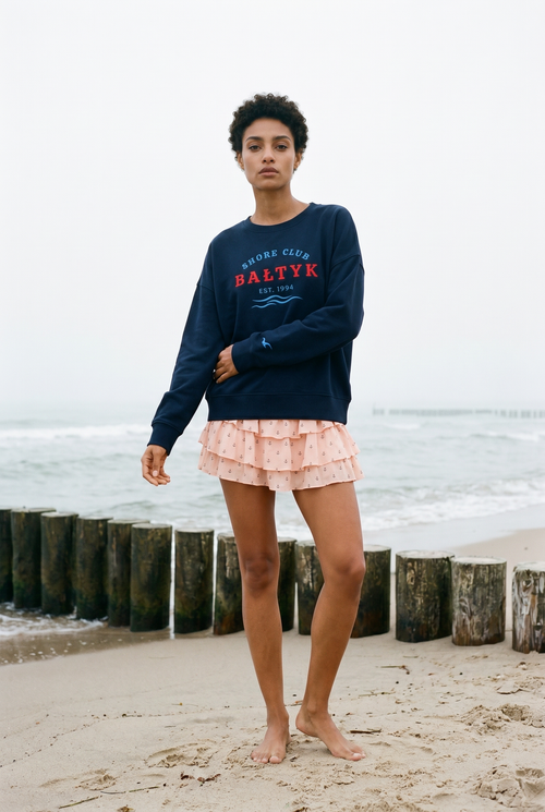 Model trägt FALA Heritage Sweatshirt Deep Baltic am Ostseestrand