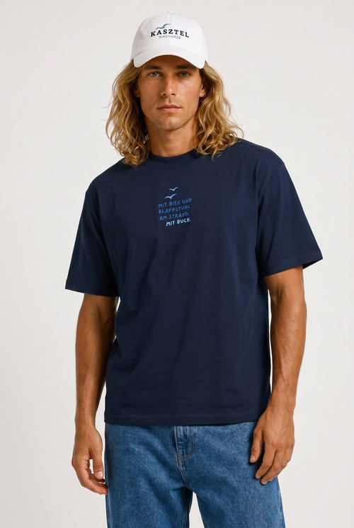 Model trägt HALO Statement T-Shirt Klappstuhl Deep Baltic von Kasztel Niechorze