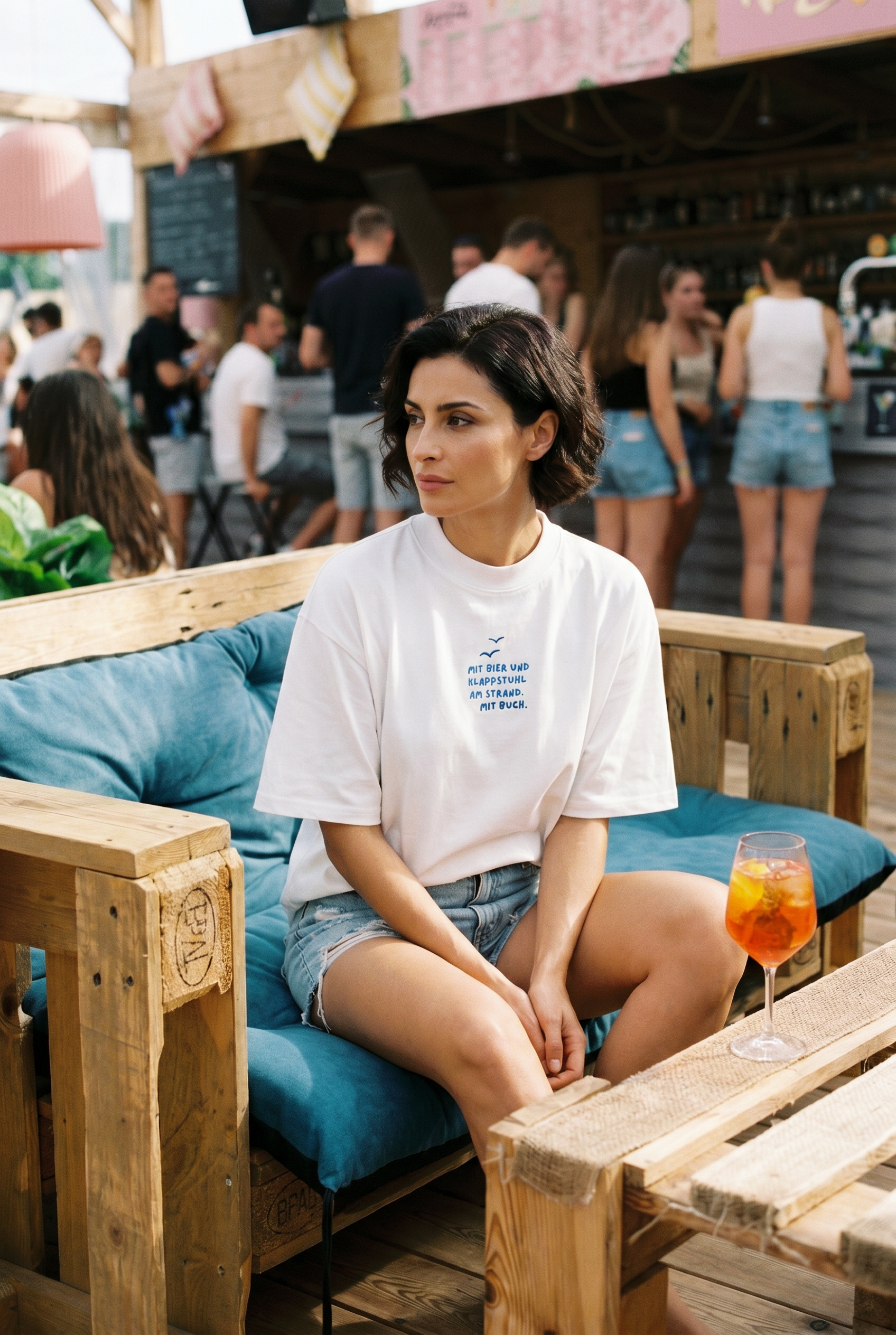 Model trägt HALO Statement T-Shirt Klappstuhl White Pearl in Strandbar