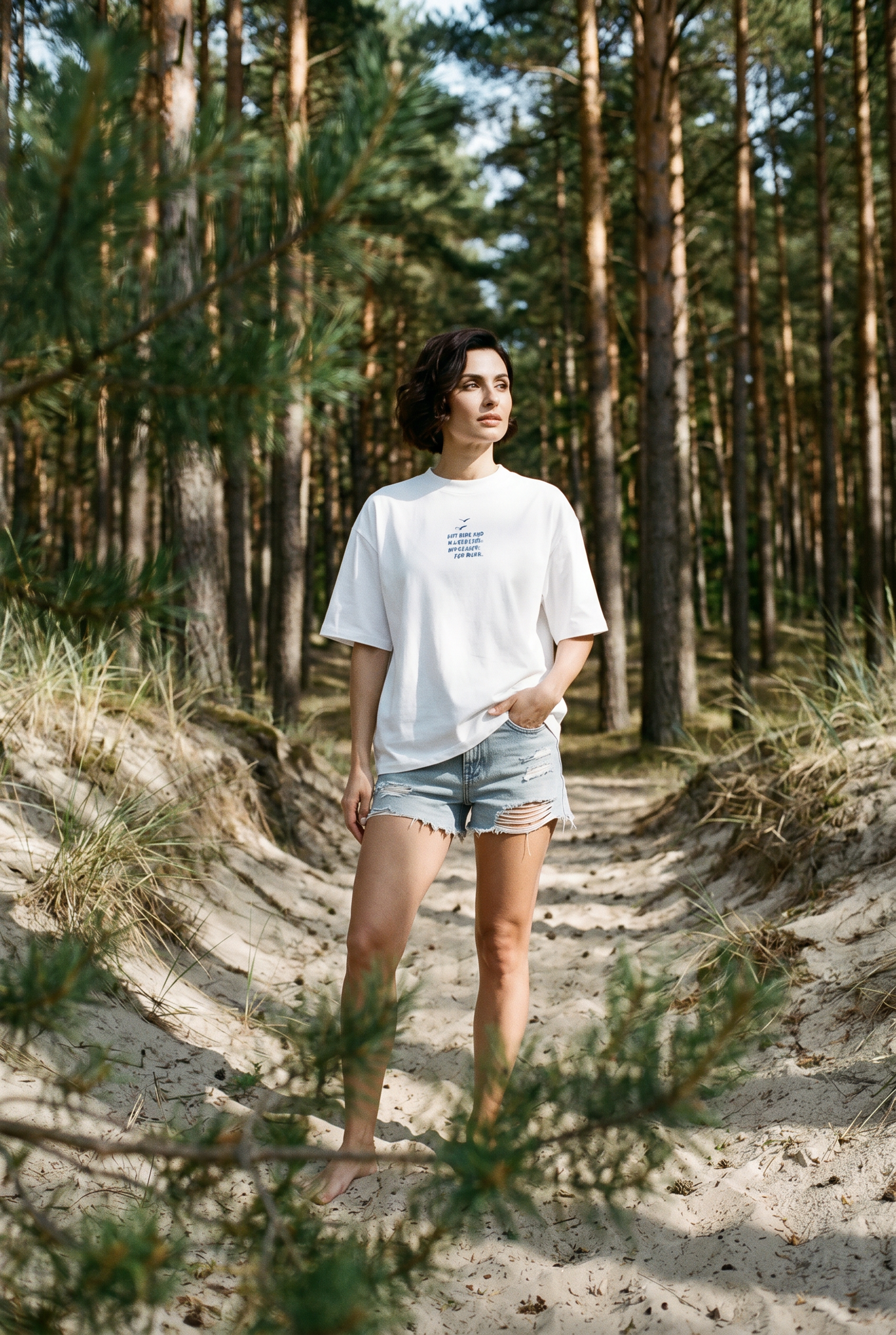 Model trägt HALO Statement T-Shirt Klappstuhl White Pearl im Kiefernwald an der Ostsee