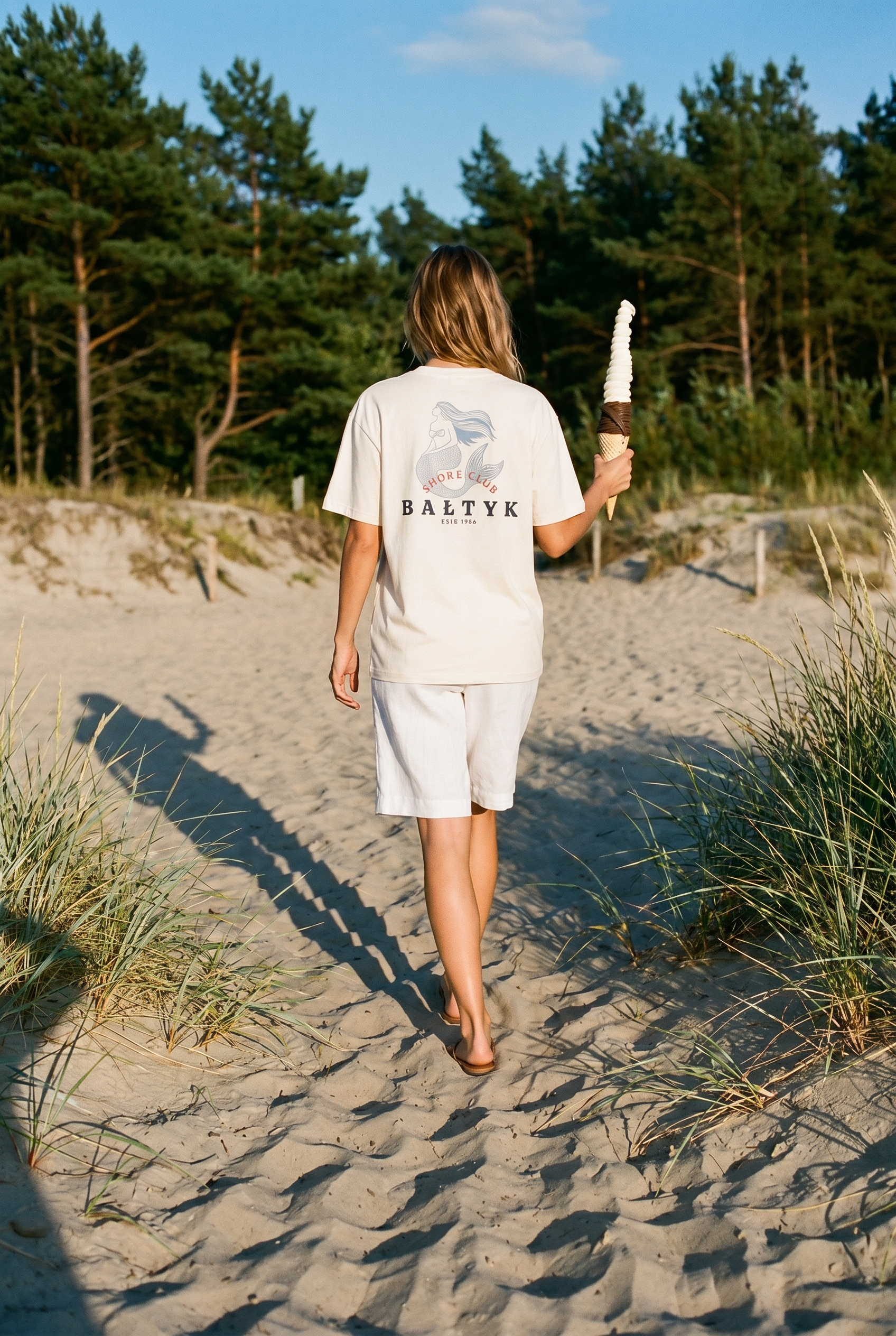Frau trägt T-Shirt mit Meerjungfrau und hält ein Softeis